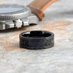 a watch sitting on top of a table next to a rubber band with colorful sprinkles