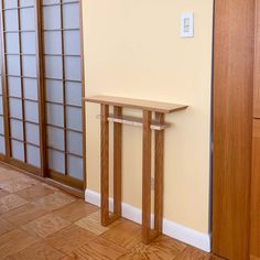 a wooden table sitting in the corner of a room