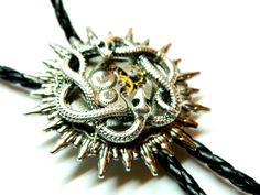 "Sun Steampunk Bolo Tie Snakes, silver or golden, with green emerald eyes, honeymoon surprise, bola fashion silver steam punk accessory clockwork, unique birthday gift mens jewelry. Black leatherette cord and moon metal pendants. Unique birthday gift, honeymoon surprise, wedding, Valentine's Day, Father's Day. Size of about 1 1/2\" / 4 cm diameter of the solar disk Length of the cord 40\" / 100 cm (including metal pendants) Made to order! more Bolo ties: https://www.etsy.com/shop/EmilySteampunk? Honeymoon Surprise, Metal Pendants, Collar Tips, Emerald Eyes, Surprise Wedding, Punk Accessories, Unique Birthday Gift, Bolo Ties, Steampunk Accessories