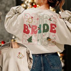 a woman wearing a white sweatshirt with the words bride on it and christmas decorations around her neck