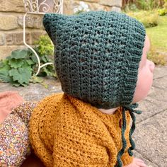 a baby wearing a crocheted hat and scarf