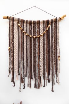 a wall hanging with beads and tassels on it