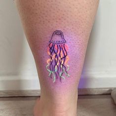 a woman's leg with a jellyfish tattoo on it