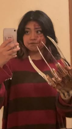 a woman taking a selfie with wine glasses in front of her and holding a cell phone