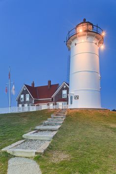 a lighthouse on top of a hill with steps leading up to it and the light house in the background