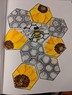 an open book with drawings of bees and sunflowers