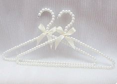 a white wedding dress hanger with pearls and bows on it's headband