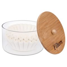 a wooden lid on a glass bowl with a white dish inside it and the word filters printed on the side