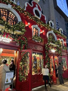 people are standing in front of a store decorated for christmas