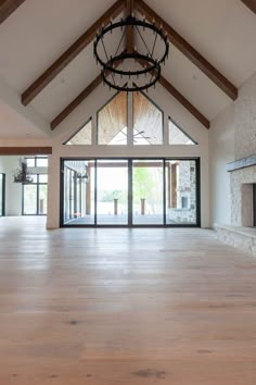 an empty room with wood floors and a chandelier