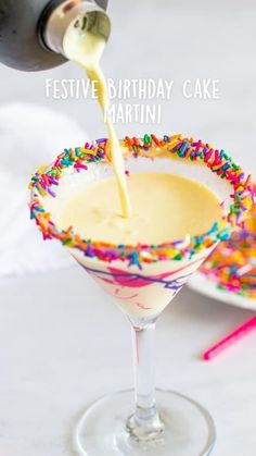 a martini being poured into a glass with sprinkles on the rim and saucer