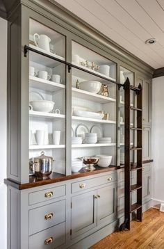 a large china cabinet with glass doors and shelves in the middle, filled with dishes