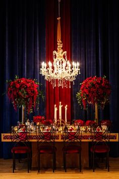 a dining room table set with red roses and candles