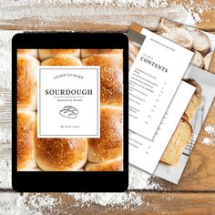 a tablet with the words sourdough on it next to some breads and papers