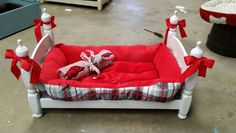 a red and white dog bed with bows on it