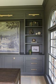 an empty room with built in bookshelves and pictures on the wall