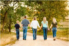 a family walking down a dirt road holding hands