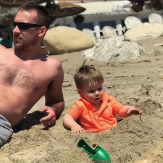 a man and his son playing in the sand