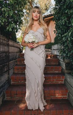 a woman in a dress standing on some steps