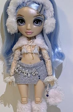 a close up of a doll with blue hair and white fur on it's head