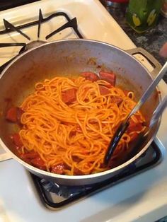 someone is cooking spaghetti in a pan on the stove