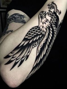 a black and white bird tattoo on the arm