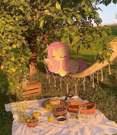 there is a hammock and some fruit on the ground in the grass near trees