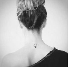 the back of a woman's neck with tattoos on it