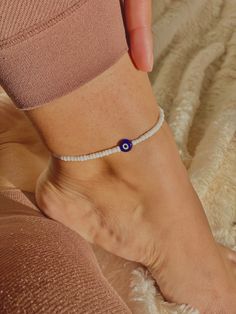 This anklet is handmade by @giftsbyshansel.  🧿Featuring White seed beads with an evil eye protection bead for added perfection. Placed inside a velvet gift pouch ready to give as a gift. Bulk orders available please contact us for more information. MATCHING RING AVAILABLE N.B Although we do our best to ensure photos shown are true to the colours of our products, actual colours may vary slightly in shade due to monitors and device resolutions used Handmade Anklets With Round Beads For Beach Season, Bohemian Evil Eye Bracelet With Tiny Beads For Beach, Bohemian Evil Eye Bracelet For Beach, Trendy Handmade Anklets For The Beach, Handmade White Anklets For Beach Season, Evil Eye Bracelet With Round Beads For Beach, Adjustable Evil Eye Anklets As Gift, Handmade White Evil Eye Bracelet For Beach, Handmade Casual Evil Eye Bracelet