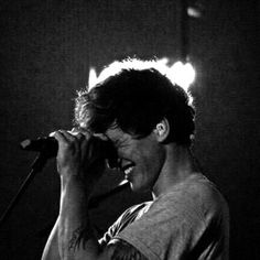 a man singing into a microphone in front of some lights