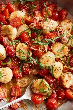 a pan filled with tomatoes and scallops on top of a table