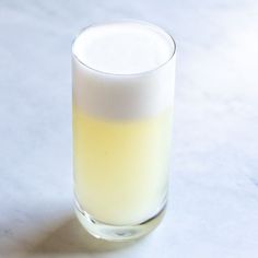 a glass filled with liquid sitting on top of a table