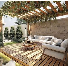 an outdoor living room with wooden flooring and white furniture on top of a wooden deck