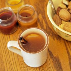 a cup filled with liquid next to some nuts