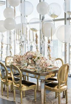 an instagramted photo of a table and chairs with balloons in the air above it