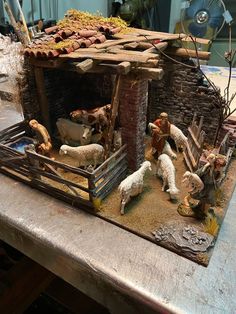 a nativity scene with sheep and goats in a mangerau made out of wood