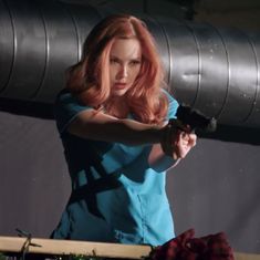 a woman with red hair holding a blow dryer