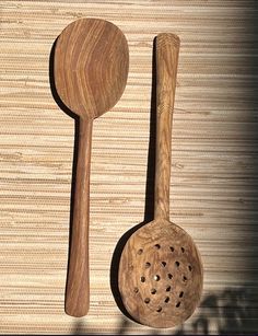 two wooden spoons and a wooden spatula on a wall