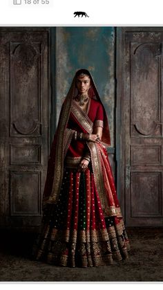 a woman in a red and gold bridal gown with her hands on her hips