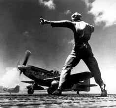 an old black and white photo of a man standing on the wing of a plane