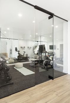 an exercise room with mirrors, treadmills and other equipment on the floor in front of glass walls