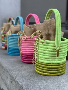 Our much loved Leandra bag comes now also in sweet candy colors, which are super special thanks to the natural shine of the fique fibers. It is handmade by Colombian artisans from Guacamayas in a traditional basketry technique of rolled dyed fibers of fica plants woven over straw fibers. The handbag is lined with a natural linen pouch finished with a golden rope drawstring and finished with the signature bronze Cuckoo B tag. We love to pair the Leandra bag with a flowy dress and flat sandals. Ma Linen Pouch, B Monogram, Traditional Baskets, Bag Green, Sweet Candy, Flowy Dress, Green Bag, Candy Colors, Natural Linen