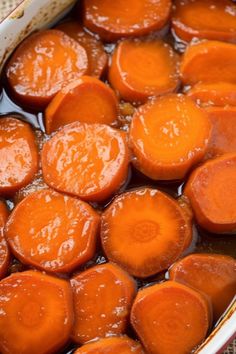 cooked carrots in oil and water in a bowl on a tablecloth covered surface