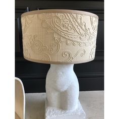 a white table lamp with a beige shade on it