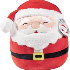 a santa clause stuffed animal sitting on top of a pillow