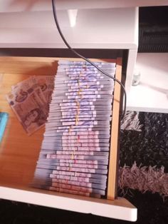 stacks of money sitting on top of a wooden shelf