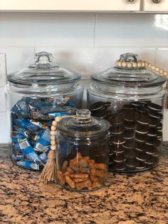 two glass jars filled with cookies on top of a counter