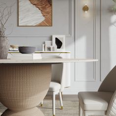 a dining room table with two chairs and a painting on the wall in the background