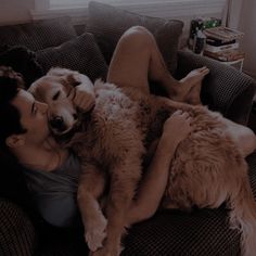 a woman laying on top of a couch next to a brown dog with her head on the back of it's owner