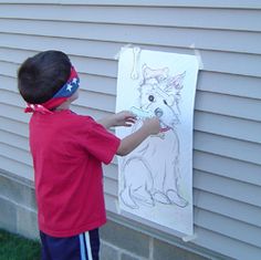 a young boy is drawing on the side of a house